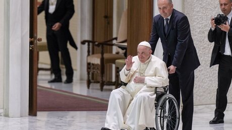 Papst Franziskus sitzt in einem Rollstuhl und winkt / © Andrew Medichini/AP (dpa)