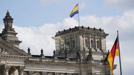 Eine Regenbogenfahne weht auf dem Südwestturm des Reichstagsgebäudes am 23. Juli 2022 in Berlin / © Jannis Chavakis (epd)