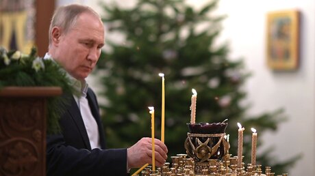Wladimir Putin, Präsident von Russland, entzündet eine Kerze / © Alexei Nikolsky/Pool Sputnik Kremlin via AP (dpa)