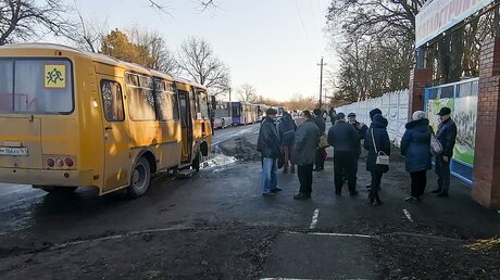 Menschen stehen an einem Bus in der Region Rostow am Don, nachdem sie aus Donezk, einem von prorussischen Kämpfern kontrollierten Gebiet in der Ostukraine, evakuiert wurden / © Uncredited/AP (dpa)