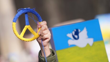 Peace-Zeichen in den ukrainischen Farben bei einer Demonstration in Berlin / © Jörg Carstensen (dpa)