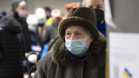 Eine ältere Dame aus der Ukraine steht nach ihrer Ankunft im Berliner Hauptbahnhof an einer Info-Säule / © Paul Zinken (dpa)