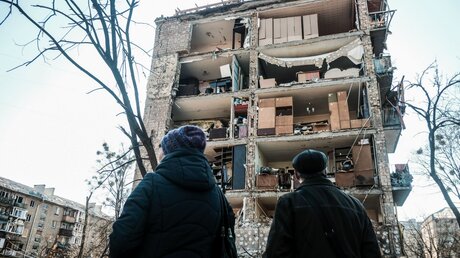 Anwohner betrachten ein zerstörtes Wohnhaus nach einem russischen Luftangriff im Wohnviertel Podil. / © Matthew Hatcher/SOPA Images via ZUMA Press Wire (dpa)