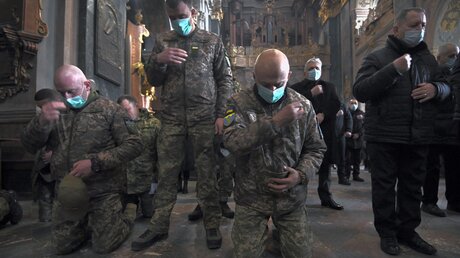 Soldaten und Einwohner beten in der Kirche der heiligen Apostel Peter und Paul in Lwiw, Ukraine. / © Carol Guzy/ZUMA Press Wire (dpa)
