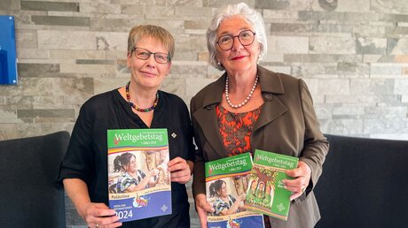 Ulrike Göken-Huismann und Brunhilde Raiser mit dem Plakatmotiv des Weltgebetstags der Frauen 2024 am 21. September 2023 in Berlin / © Michael Kinnen (KNA)