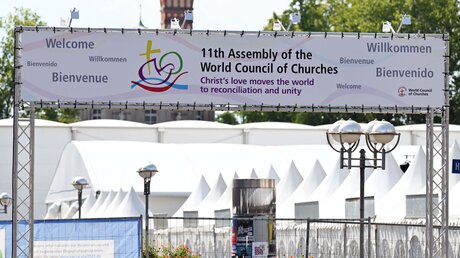  Karlsruhe: Beim Festplatz weist ein Banner auf die 11. Vollversammlung des Ökumenischen Rates der Kirchen hin / © Uli Deck (dpa)