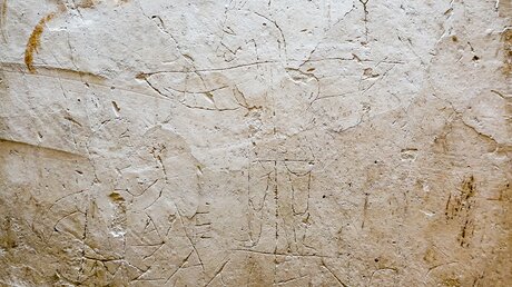 Das Graffito 'Alexamenos betet seinen Gott an' zeigt die Darstellung eines gekreuzigten Christus mit Eselskopf. Es ist ein Graffito aus einer Wachtstube des Kaiserpalastes auf dem Palatin in Rom, vermutlich aus der Zeit um 125 nach Christus. / © Michael Merten (KNA)