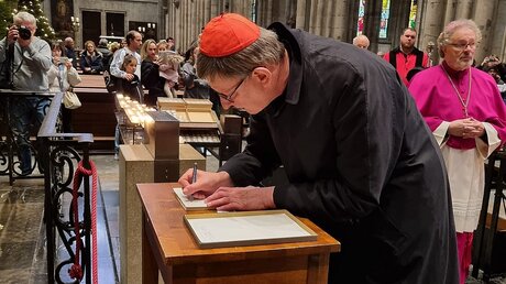 Kardinal  Woelki trägt sich in das Kondolenzbuch für Benedikt XVI. ein (DR)