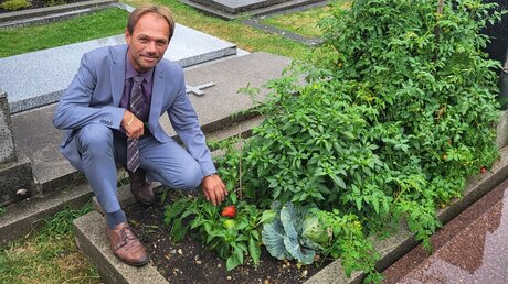 Friedhofsverwalter Walter Pois zeigt bepflanztes Grab (privat)