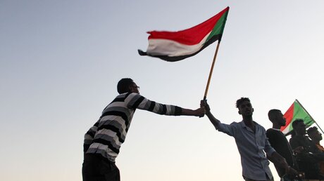 Demonstranten mit der sudanesischen Flagge / © Wirestock Creators (shutterstock)