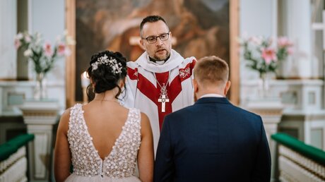 Ein Priester segnet ein Hochzeitspaar (shutterstock)