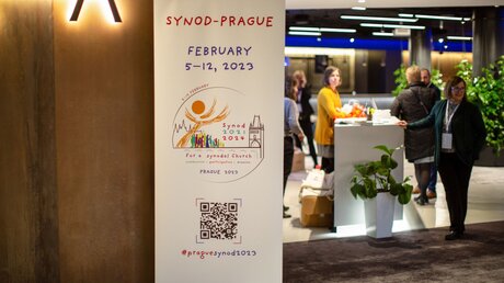 Rollup mit dem Logo der Synodalen Versammlung am 5. Februar 2023 in der Lobby des Hotels Pyramida in Prag. / © Björn Steinz (KNA)