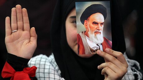 Junge Frau mit einem Bild von Ayatollah Khomeini / © Marwan Naamani (dpa)