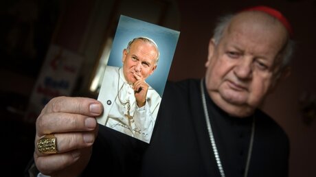 Kardinal Stanislaw Dziwisz mit einem Bild von Papst Johannes Paul II. / © Marcin Mazur (KNA)