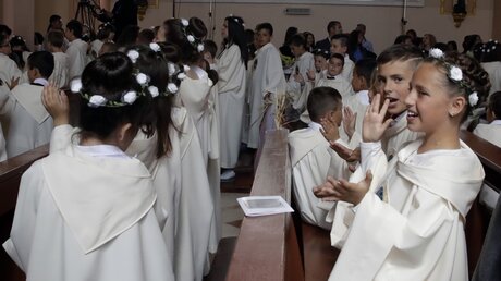 Kinder freuen sich auf die Austeilung der Heiligen Kommunion durch den Papst / © Alessandra Tarantino (dpa)