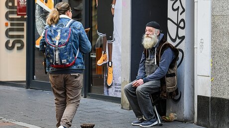 Klaus sitzt an einer Fußgängerzone in Bonn. Einige Monate zuvor trägt Klaus noch einen anderen Bart. / © Harald Oppitz (KNA)