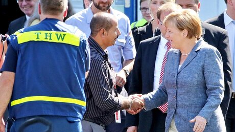 Kanzlerin Angela Merkel am 26.8.15 mit einem Helfer in einer Flüchtlingsunterkunft in Heidenau (dpa)