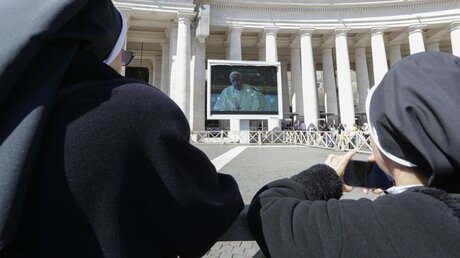 Nonnen und Gläubige bei der Live-Übertragung des Angelus-Gebetes auf dem Petersplatz / © Andrew Medichini (dpa)