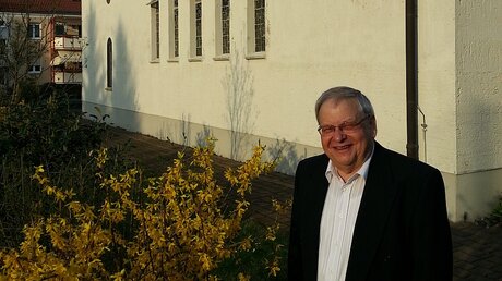 Pfarrer Peter Opitz vor seiner Kirche in Heidenau  / © Opitz