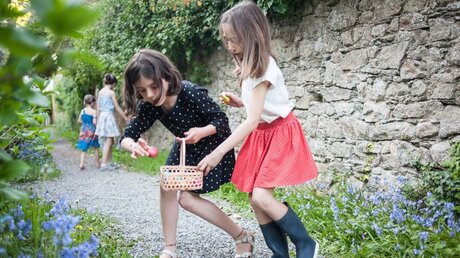Ostereiersuche: Zwei Mädchen legen Ostereier in ein Körbchen / © Julie Subiry (KNA)