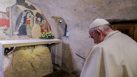 Papst Franziskus betet in der Grotte, in der Franz von Assisi Weihnachten gefeiert hatte, am 1. Dezember 2019 in Greccio / © Vatican Media (KNA)