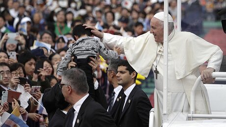 Papst Franziskus segnet ein Kind im Stadion  / © Gregorio Borgia (dpa)