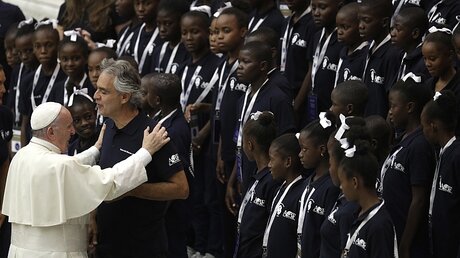 Papst Franziskus umarmt den italienischen Sänger Andrea Bocelli, der mit dem Kinderchor "Voices of Haiti" auftrat / © Gregorio Borgia (dpa)