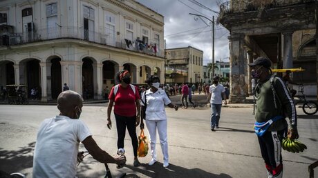 Passanten gehen in Kuba mit Masken durch die Straßen / © Ramon Espinosa (dpa)