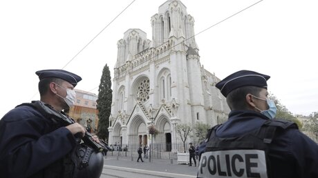 Polizeibeamte stehen in der Nähe des Tatorts einer Messerattacke vor der Kirche Notre-Dame in Nizza / © Eric Gaillard (dpa)