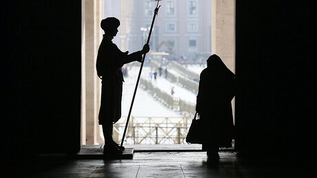 Alltag im Vatikan: Ein Gardist steht Wache während eine Nonne vorbeigeht / © Alessandro Di Meo/Pool (dpa)