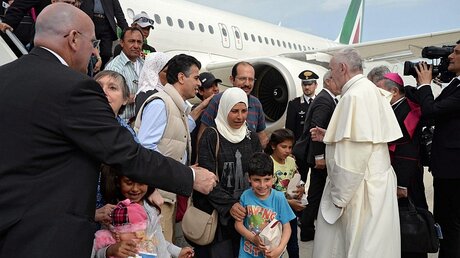 Papst Franziskus begrüßt die mitgereisten Flüchtlinge auf dem Flughafen in Rom  / © Filippo Monteforte (dpa)
