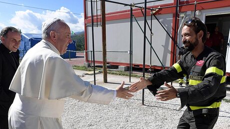 Der Heilige Vater begrüßt einen Feuerwehrmann in Cittareale / © Osservatore Romano (dpa)