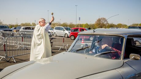 Priester Frank Heidkamp segnet die Gottesdienstteilnehmer in ihren Autos nach der Ostermesse / © Theo Barth (KNA)