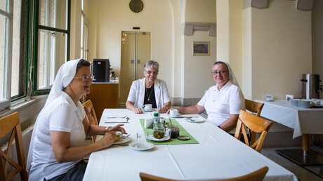 Schwester Heidrun Raabe (m.), Leiterin des Paulushauses, sitzt zusammen mit zwei Schwestern am Tisch im Paulushaus in Jerusalem. / © Andrea Krogmann (KNA)