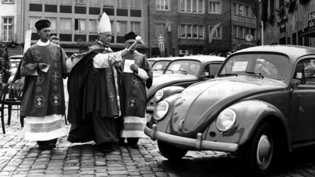 Segnung von VW Käfern im September 1957 durch Alex Gabriel, Geschäftsführer des Bonifatiuswerkes, in Paderborn / © N.N. (KNA)