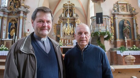 Der katholische Pfarrer Hans Zeltsperger und der evangelische Pfarrer Konrad Schornbaum (v.l.n.r.) / © Armin Weigel (dpa)