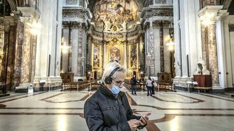 Tourist mit Mundschutz in der Kirche Sant'Andrea delle Fratte / © Stefano Dal Pozzolo (KNA)