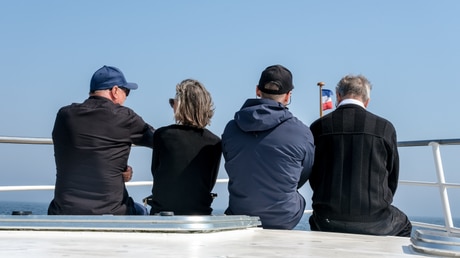 Trauergäste sitzen am Bug des Schiffes MS Seewind vor der Seebestattung in der Ostsee / © Jozef Kubica (KNA)