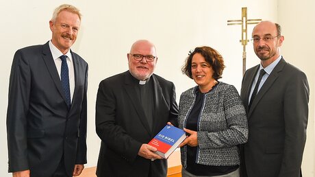 Vertreter des Katholischen Bibelwerks übergeben die neue Einheitsübersetzung der Bibel an Kardinal Reinhard Marx / © Harald Oppitz (KNA)