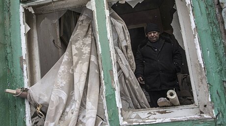 Ein Mann steht am 02.02.2017 in seinem von Granaten zerschossenen Haus in Awdijiwka in der Ostukraine. / ©  Evgeniy Maloletka (dpa)
