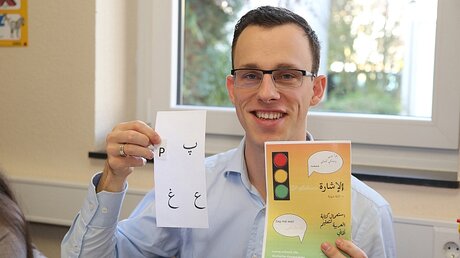 Vikar Benjamin Graf hilft beim Deutsch lernen / © Thomas Rohnke (epd)