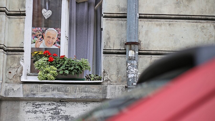 Ein Porträt des winkenden Papst hängt in einem Fenster im ehemaligen jüdischen Stadtviertel Kazimierz in Krakau in Polen. / © Markus Nowak (KNA)