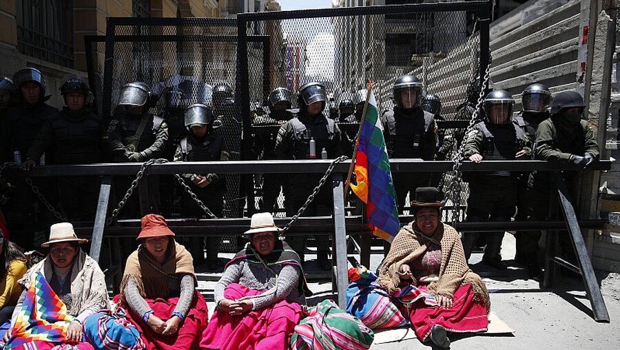 Anhänger von Morales sitzen vor Absperrung der Polizei (dpa)