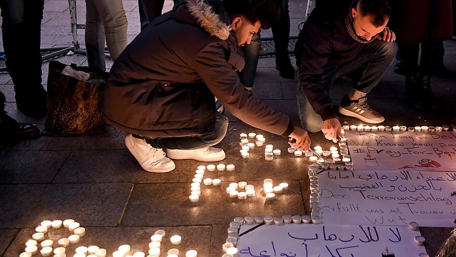 Flüchtlinge aus dem Irak zünden Kerzen am Berliner Breitscheidplatz an / © Britta Pedersen (dpa)