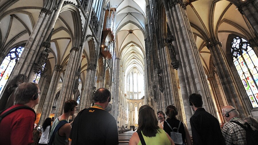 Besucher des Kölner Doms bestaunen das Deckengewölbe / © Tjalke Weber (KNA)