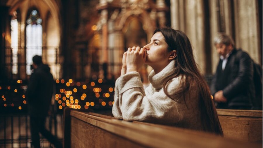Betende Frau in einer Kirche (shutterstock)