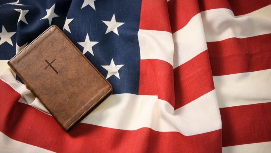 Bibel und US-Flagge / © Julia Steinbrecht (KNA)