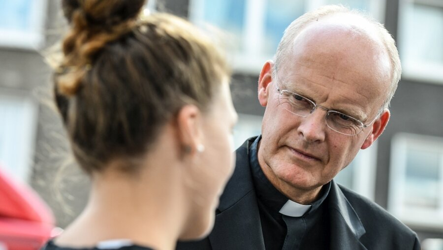Bischof Franz-Josef Overbeck im Gespräch mit einer jungen Frau (Archiv) / © Harald Oppitz (KNA)