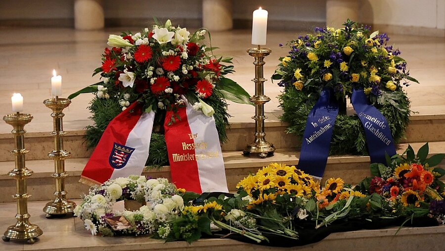 Blumenkränze und Kerzen beim Trauergottesdienst / © Joachim Storch (dpa)