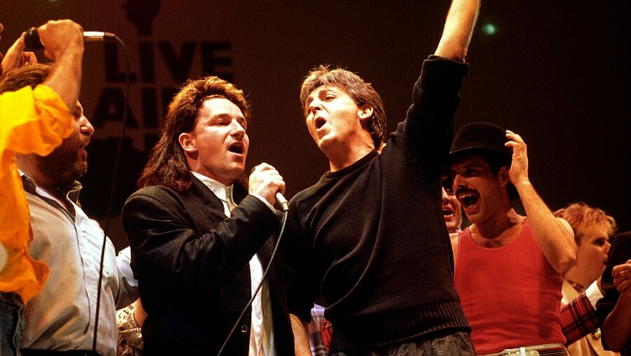 Bono (l-r), Paul McCartney und Freddy Mercury am 13.07.1985 beim Live Aid Konzert / © PA Wire (dpa)